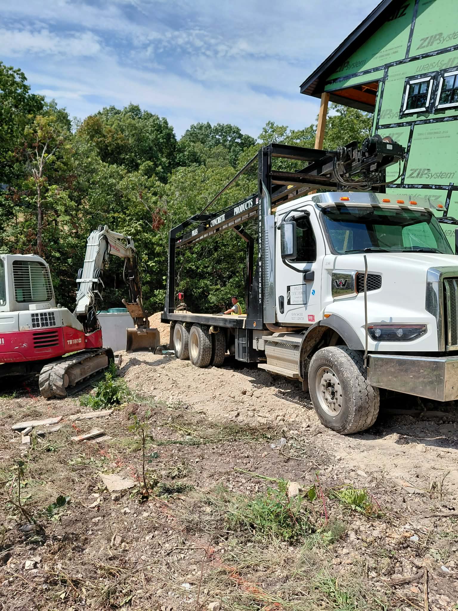 NWA Septics white truck and excavator at construction site