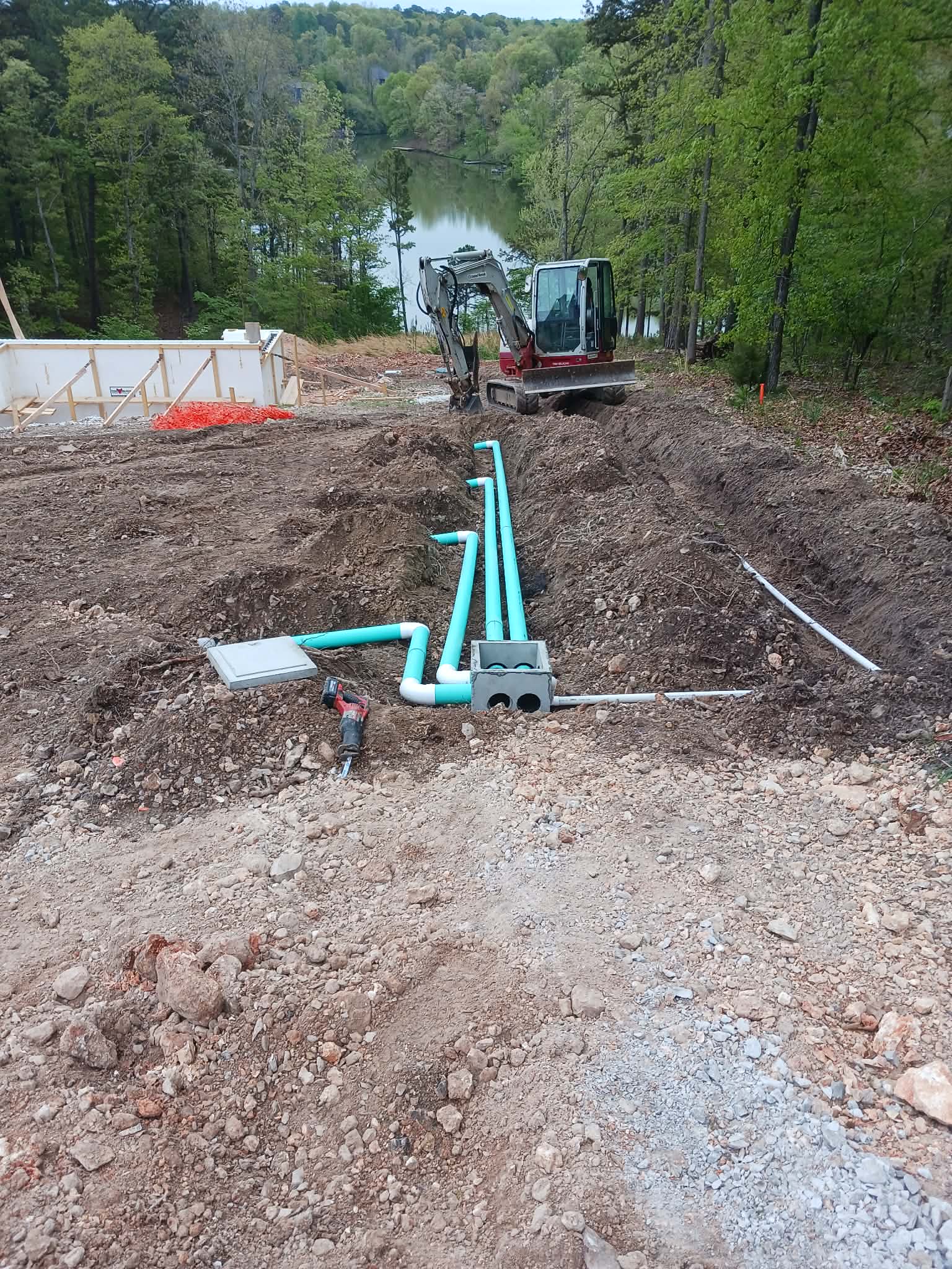 Septic pipe installation by a lakeside with excavator